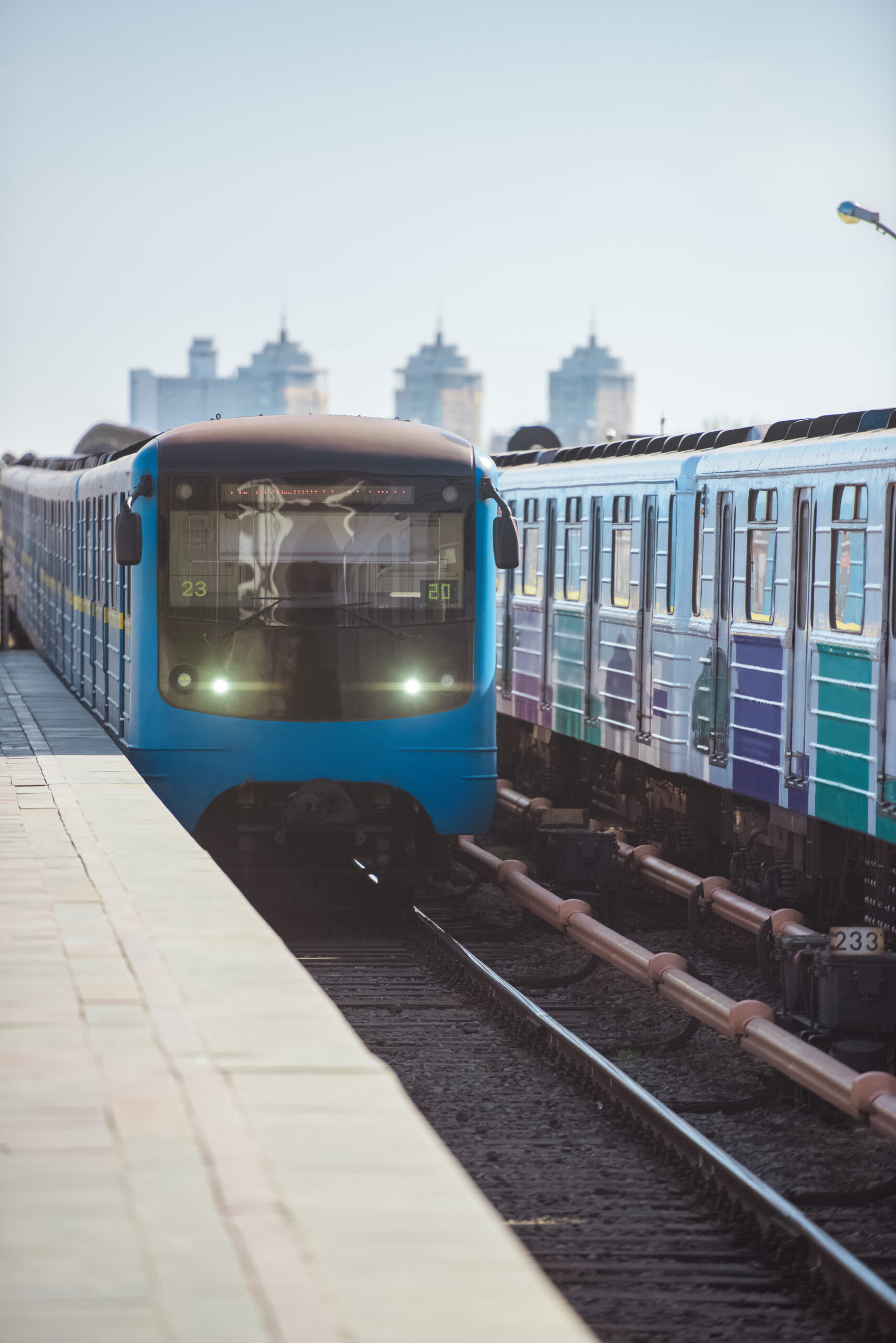 trains at outdoor subway station with buildings on background